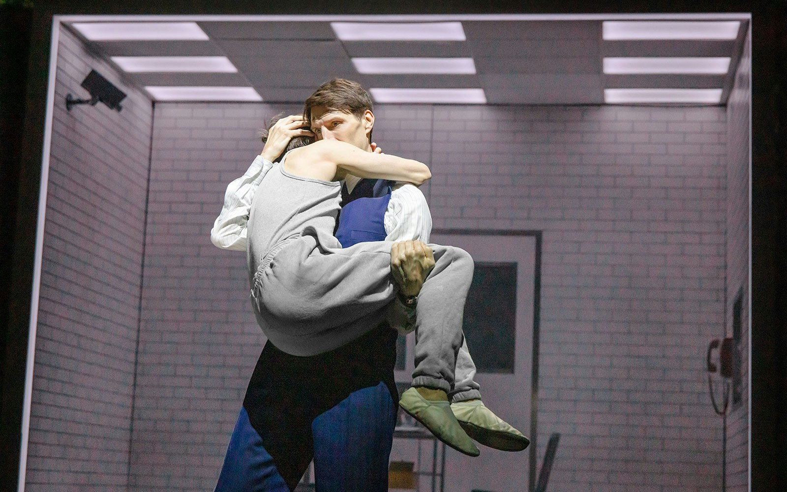 Two people embrace in a dimly lit room, evoking a scene from Stranger Things.