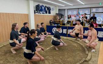Participants in a sumo workshop learning traditional techniques in a Tokyo dojo.