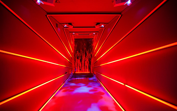 Immersive red-lit hallway at Remastered audiovisual experience, Rotterdam.