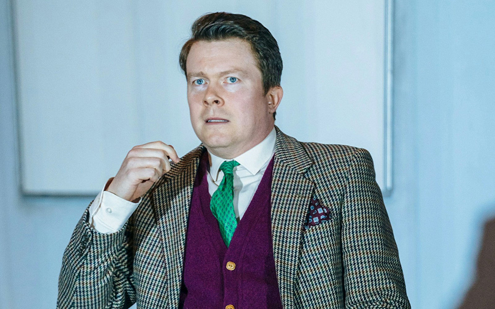 Man in a suit performing in "Accidental Death of an Anarchist" play.