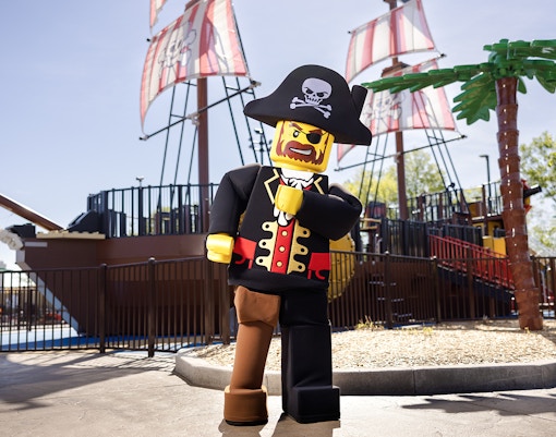 Pirate-themed Lego character in front of a ship at Legoland, New York.