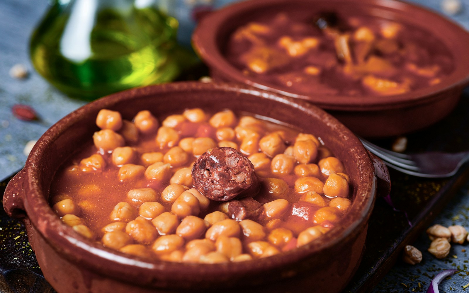 Spanish chickpeas and garbanzo beans tomato stew in a rustic bowl.