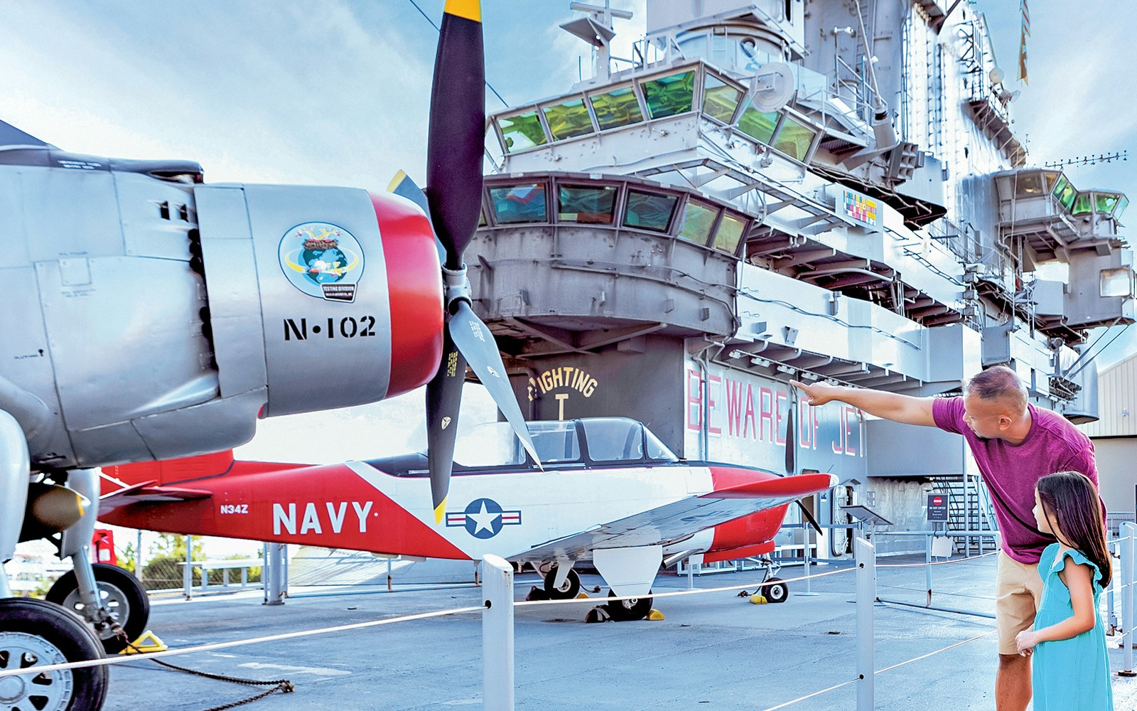 Father and daughter observing historic aircraft at Intrepid Museum, New York.