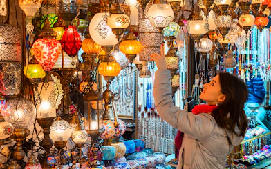 Young woman browsing colorful Turkish lamps in the Grand Bazaar, Istanbul.