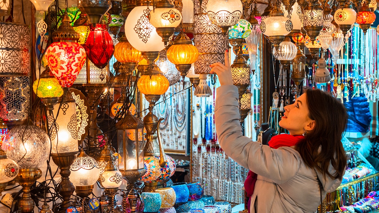 Young woman browsing colorful Turkish lamps in the Grand Bazaar, Istanbul.