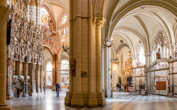 Toledo Cathedral interior with ornate stone carvings and vaulted ceilings.