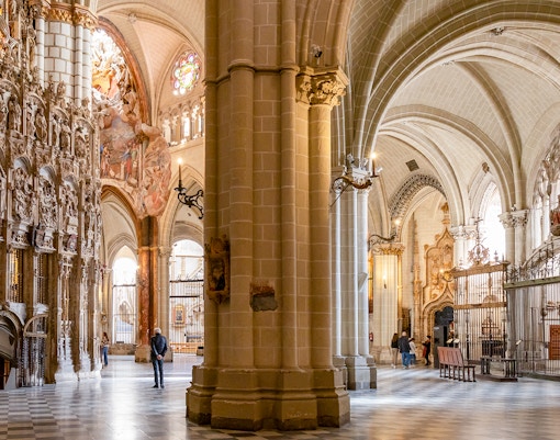 Toledo Cathedral interior with ornate stone carvings and vaulted ceilings.