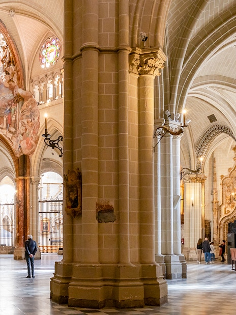 Toledo Cathedral interior with ornate stone carvings and vaulted ceilings.