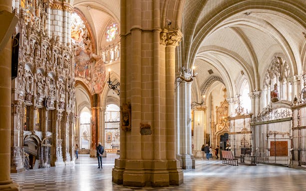 Toledo Cathedral interior with ornate stone carvings and vaulted ceilings.