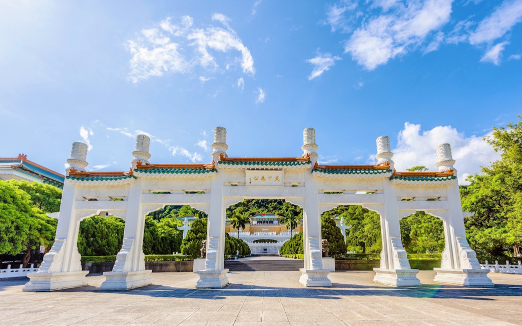 Entrance gate of Taiwan Palace Museum with traditional architecture and blue sky.