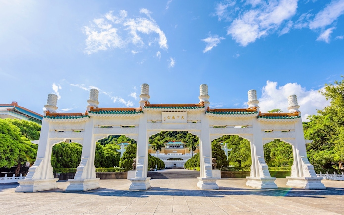 Entrance gate of Taiwan Palace Museum with traditional architecture and blue sky.