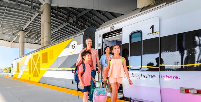 Family boarding Brightline train from Miami to Orlando.