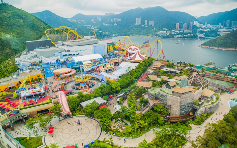 Aerial view of Ocean Park Theme Park with roller coasters and scenic bay in Hong Kong.