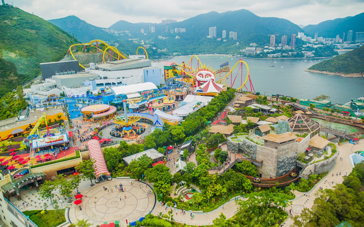 Aerial view of Ocean Park Theme Park with roller coasters and scenic bay in Hong Kong.