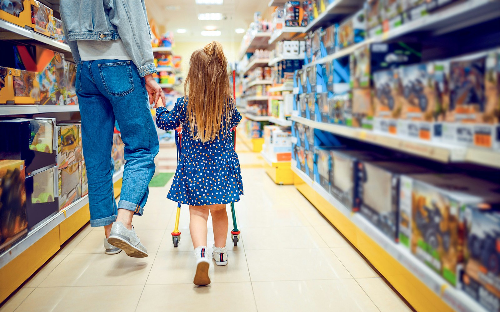 Parent and child shopping in a London toy store aisle.