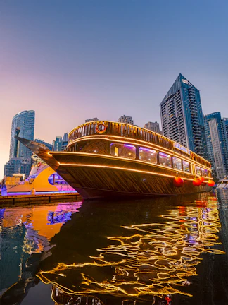 Alexandra Dhow Cruise illuminated at Dubai Marina during sunset.