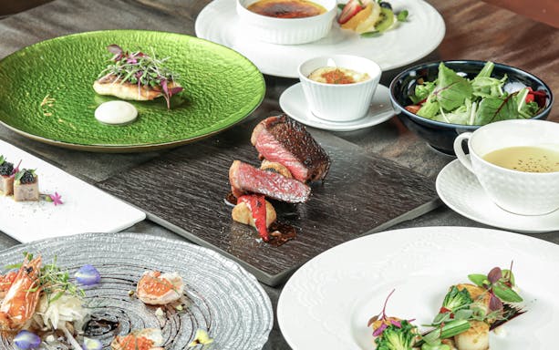 Kobe Steak & Cafe Nobleurs dining table with assorted delicacies including steak, salad, and dessert.