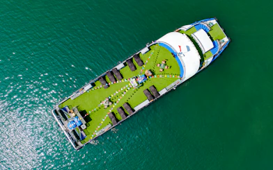 Aerial view of a cruise ship deck with sun loungers and seating, Ha Long Bay.