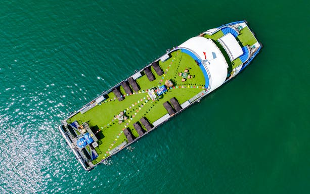Aerial view of a cruise ship deck with sun loungers and seating, Ha Long Bay.