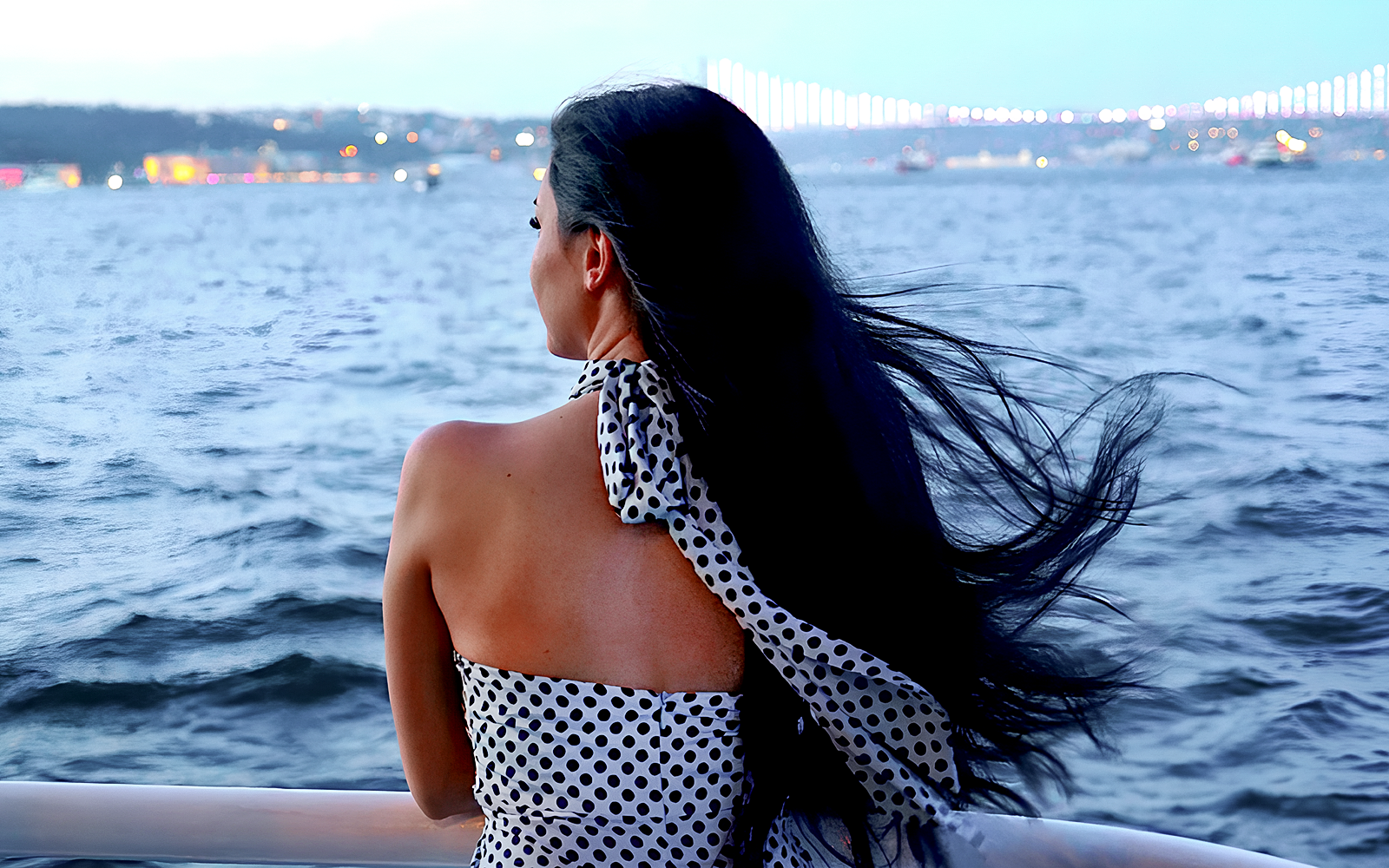 Person enjoying Bosphorus cruise with Istanbul skyline in the background.