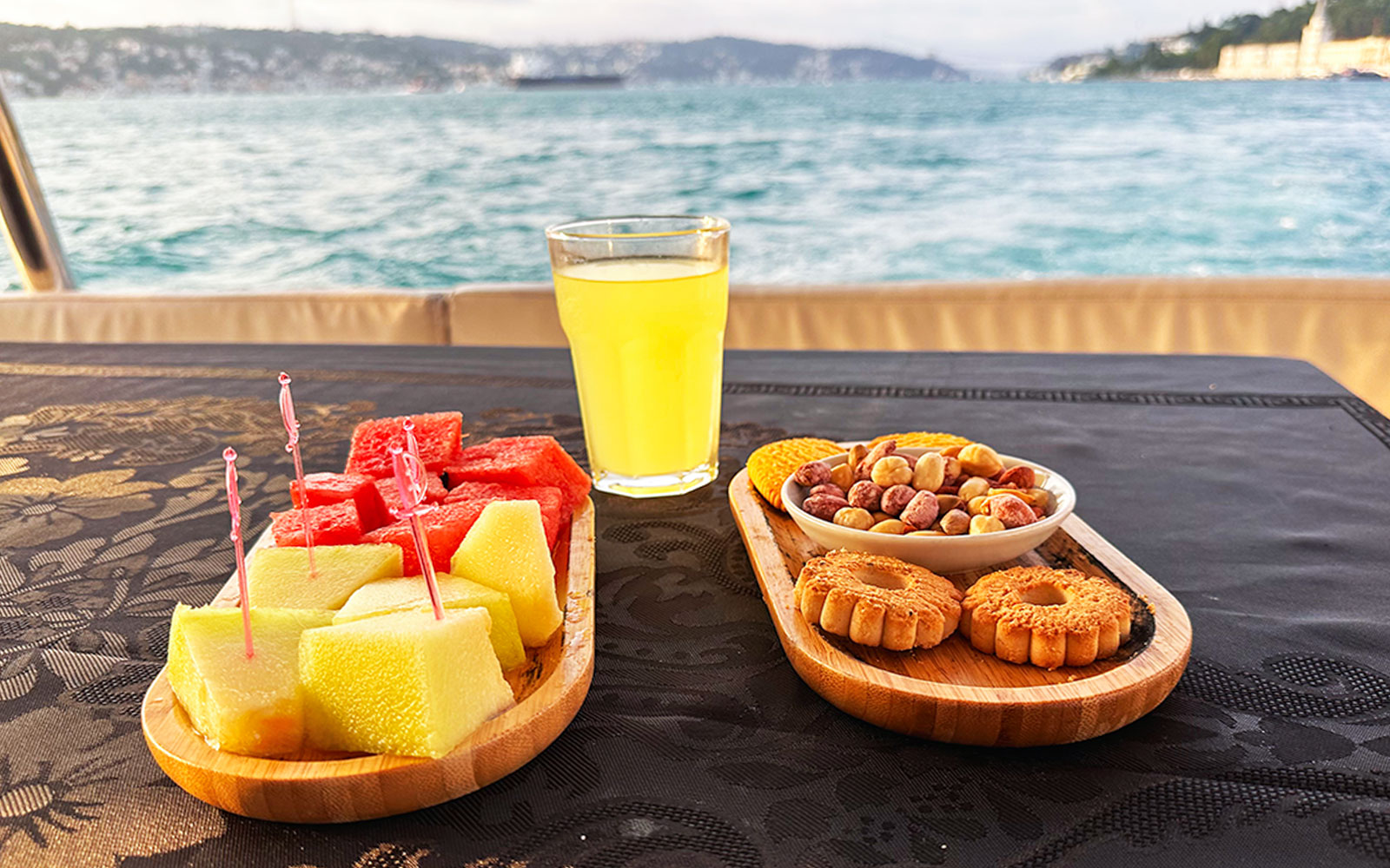 Fruit, nuts, and a drink on a yacht table during Bosphorus & Golden Horn sunset cruise.