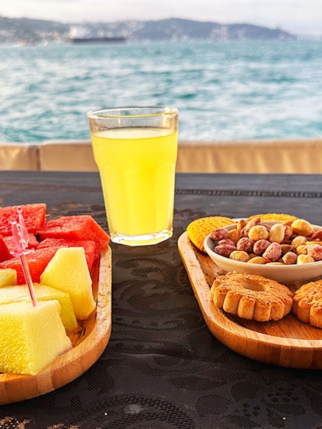 Fruit, nuts, and a drink on a yacht table during Bosphorus & Golden Horn sunset cruise.