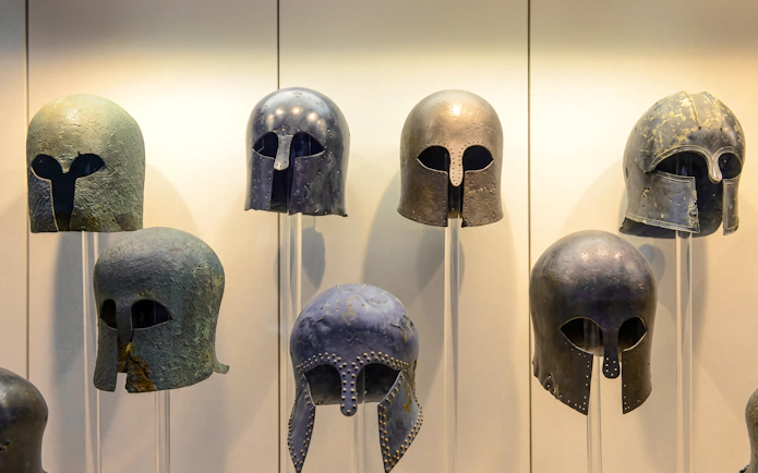 Ancient Greek helmets displayed at the Archaeological Museum in Olympia.