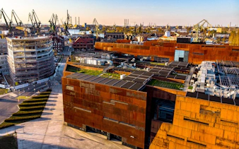 European Solidarity Centre exterior with shipyard cranes in Gdańsk, Poland.