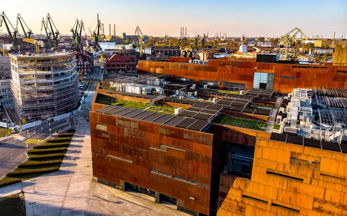 European Solidarity Centre exterior with shipyard cranes in Gdańsk, Poland.