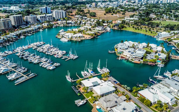 Aerial view of Darwin marina with boats and waterfront homes, part of Big Bus Darwin tour.