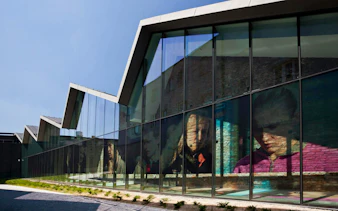 Krakow museum exterior with reflective glass facade displaying historical images.