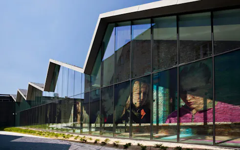 Krakow museum exterior with reflective glass facade displaying historical images.