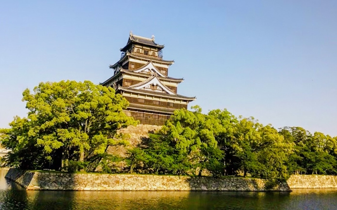 Hiroshima Castle surrounded by trees and a moat in Hiroshima, Japan.