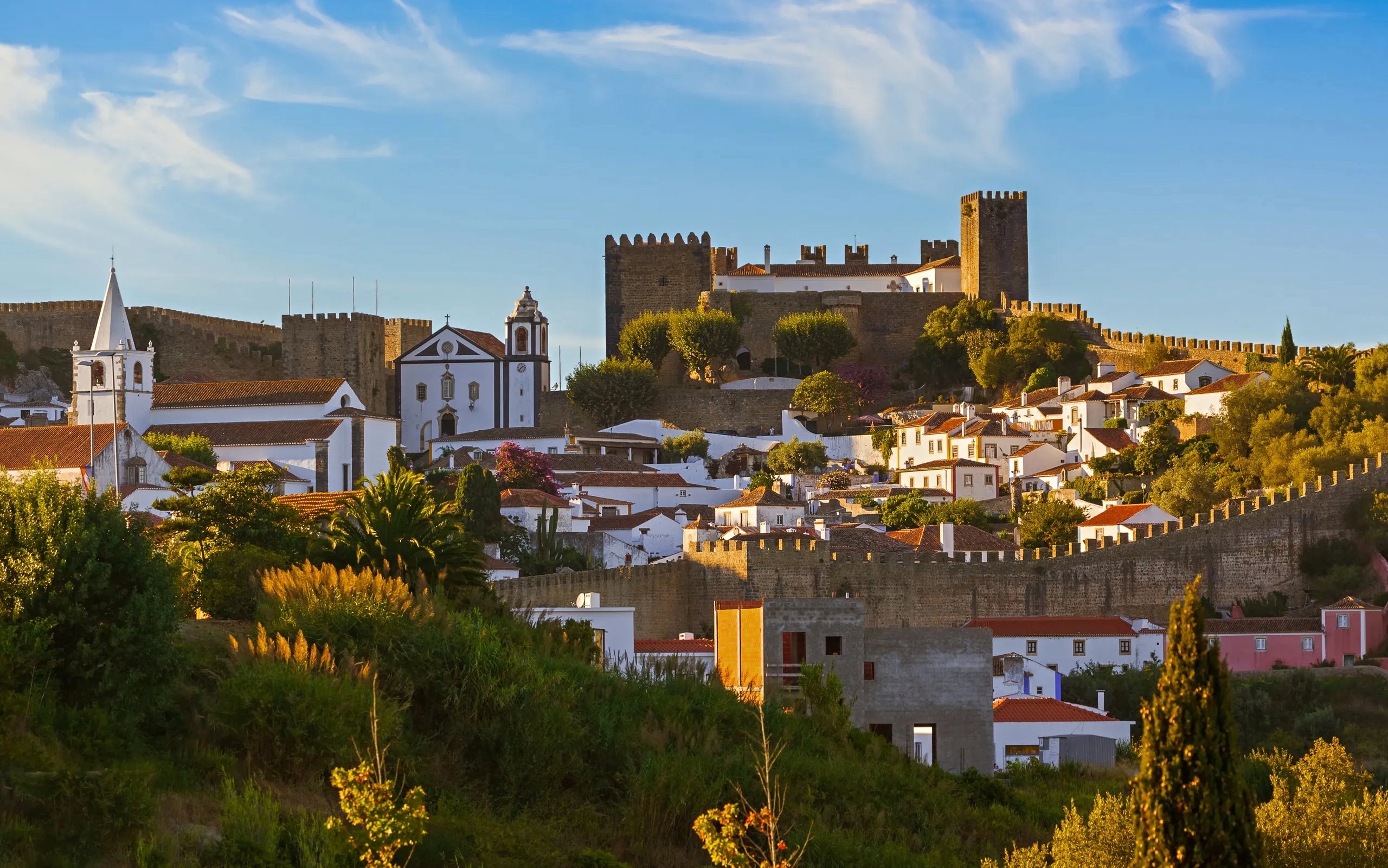Óbidos townscape with medieval castle and whitewashed houses in Portugal.