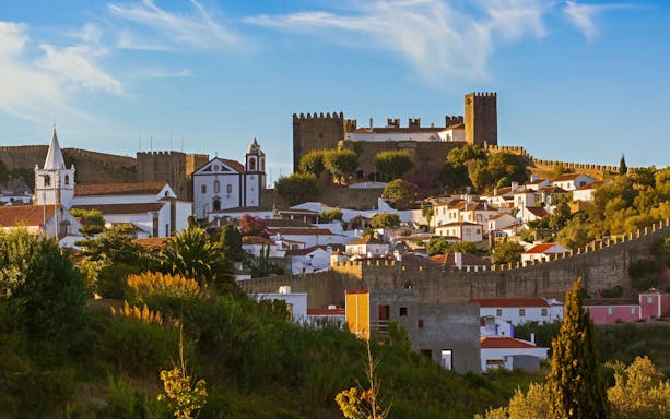 Óbidos townscape with medieval castle and whitewashed houses in Portugal.