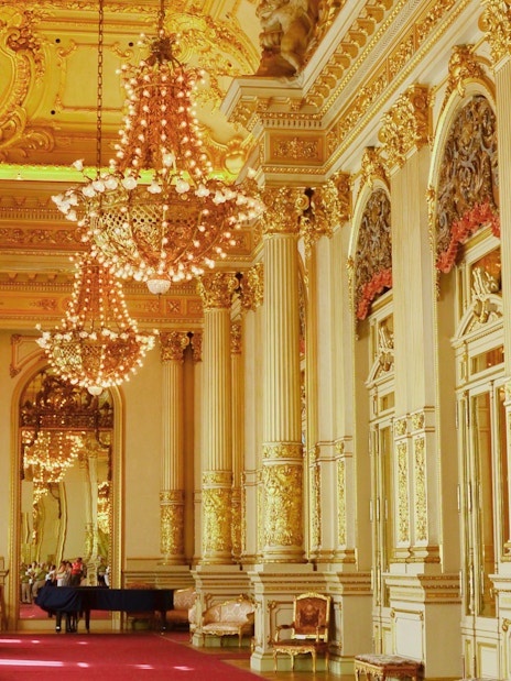 Ornate interior of Teatro Colon with chandeliers and gilded columns.