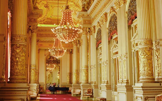 Ornate interior of Teatro Colon with chandeliers and gilded columns.