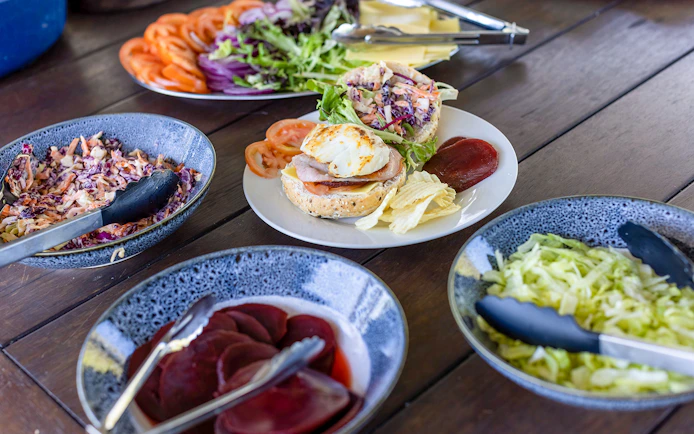 Lunch spread with salad, sandwich, and condiments on Top End Safari Camp Day Tour near Finniss River.