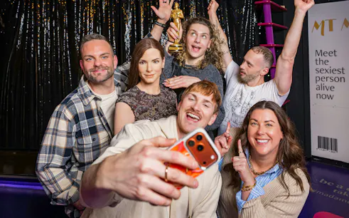 Group taking selfie with wax figure at Madame Tussauds Vienna.