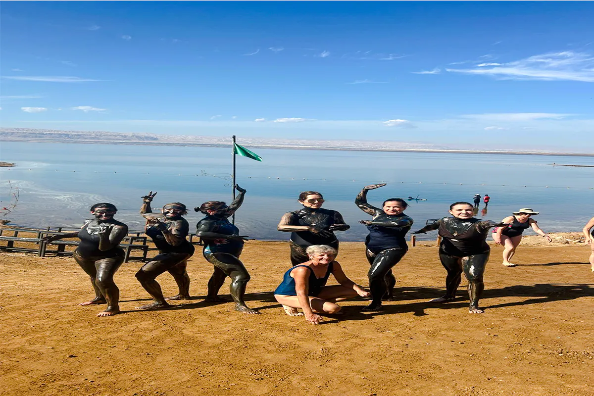 Group enjoying mud bath by the Dead Sea during Amman half-day trip.