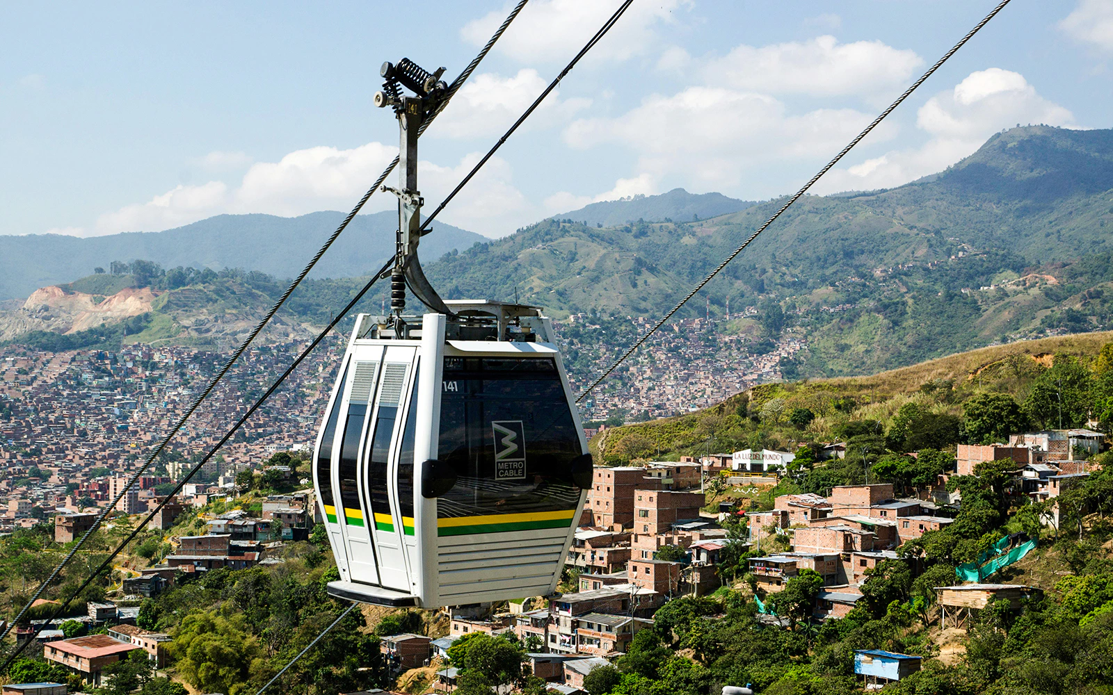 Cable car over Medellin with cityscape and mountains in the background.