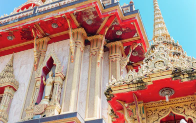 Wat Chalong temple architecture in Phuket, featuring ornate red and gold details.