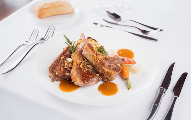 Seine River lunch cruise meal with lamb chops and vegetables.