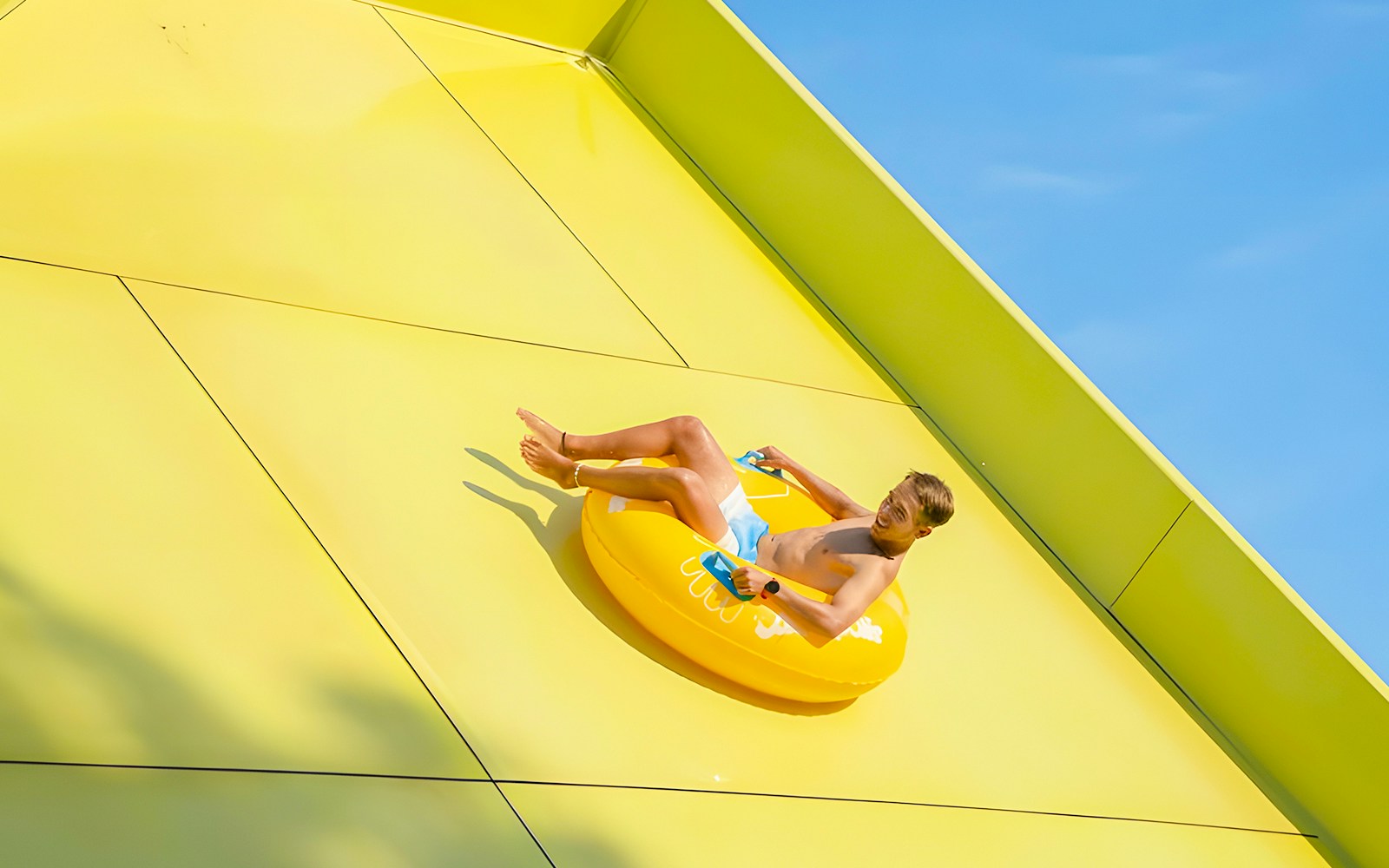 Person sliding on Boomerang ride at Aquopolis Torrevieja water park.