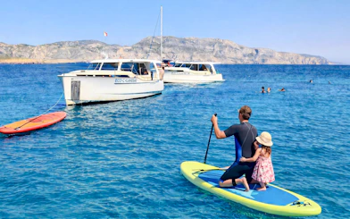 Paddleboarding near boats in the Frioul Archipelago, France.