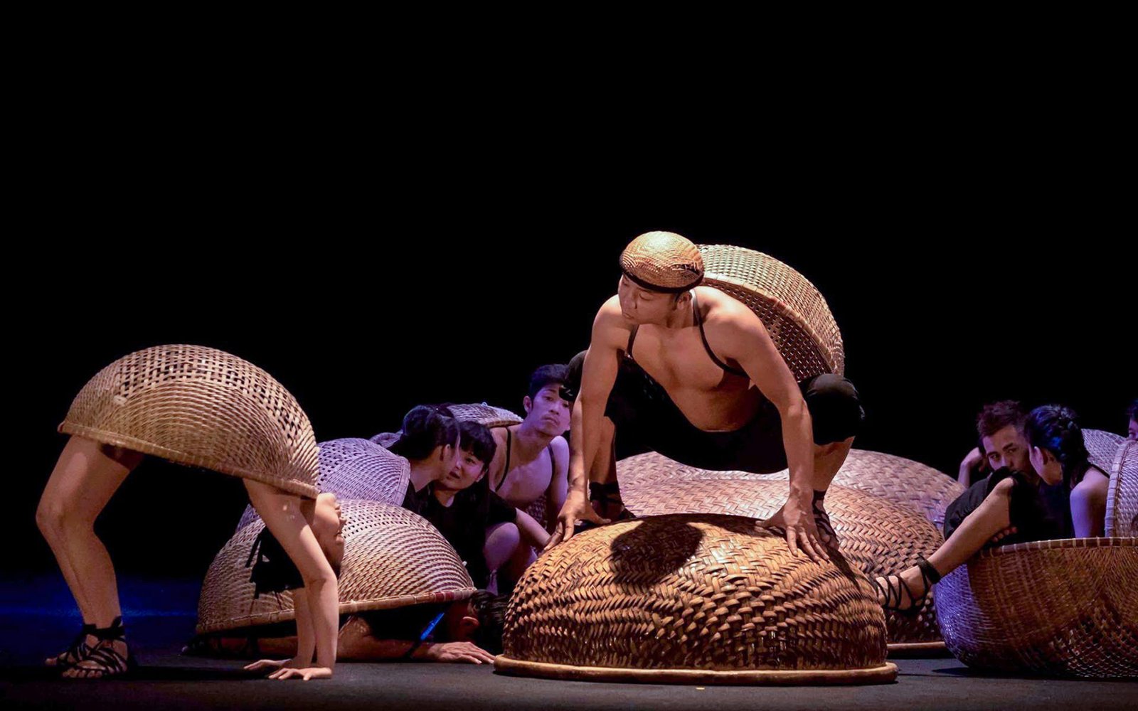 Performers with baskets at A O Show circus in Vietnam.