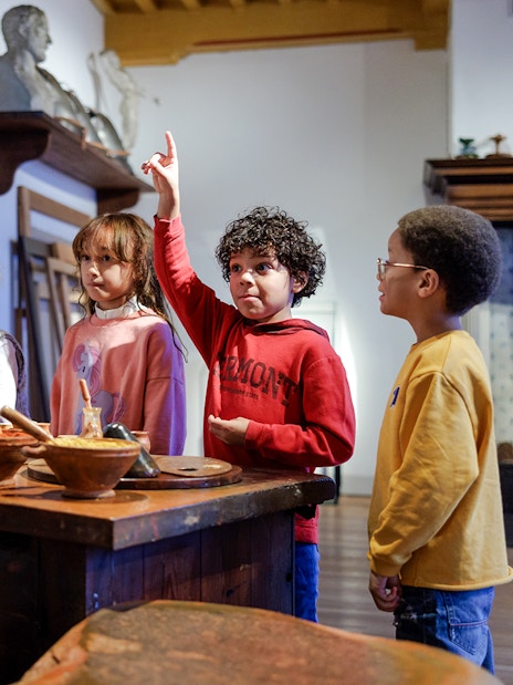 Children engaging with a guide at Rembrandt House Museum, Amsterdam.