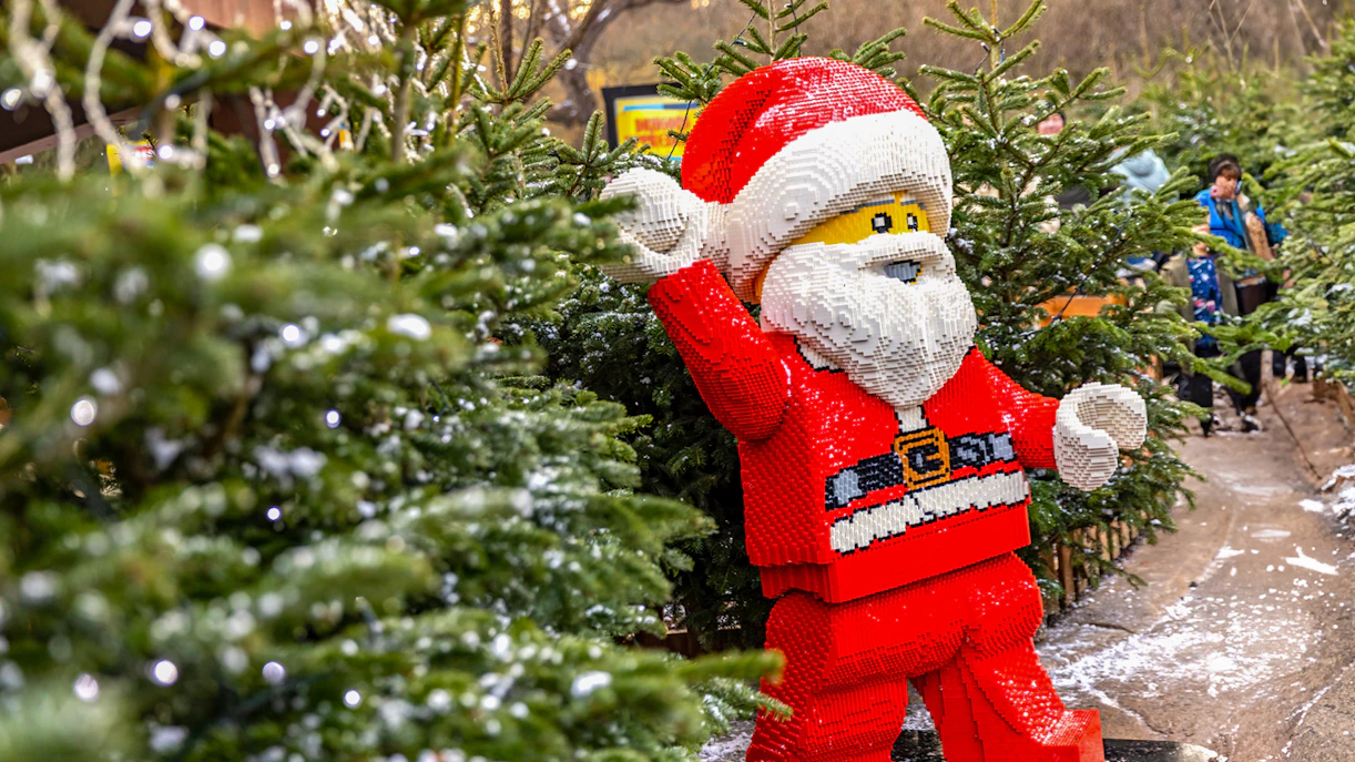 Lego Santa Claus among Christmas trees at Legoland London holiday display.