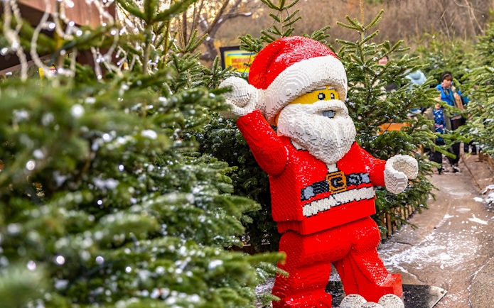 Lego Santa Claus among Christmas trees at Legoland London holiday display.