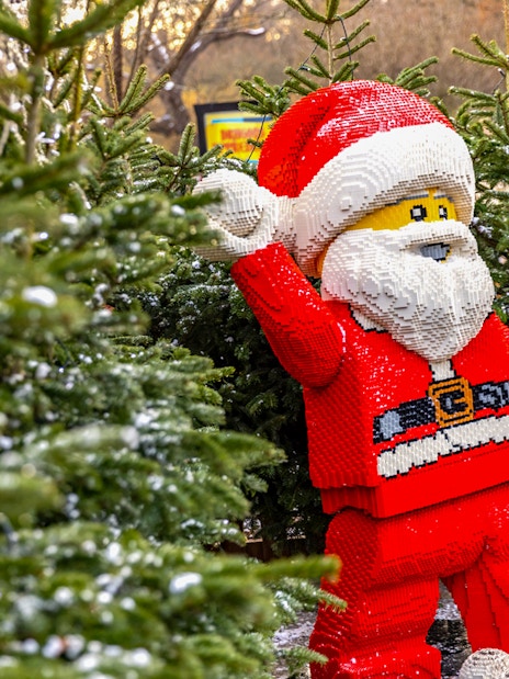 Lego Santa Claus among Christmas trees at Legoland London holiday display.